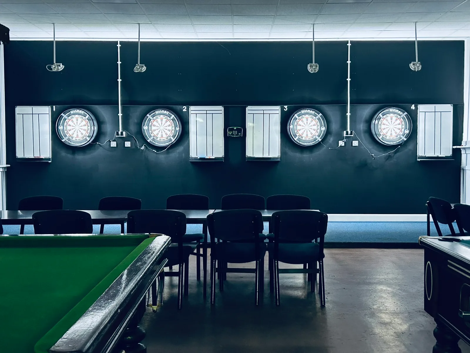 Four dartboards and scoring boards in the games room